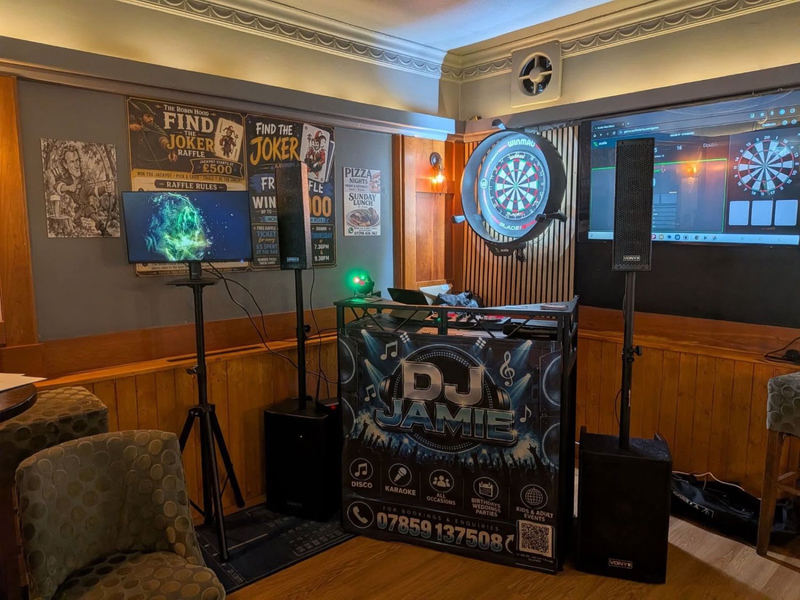 DJ Jamie booth with speakers, screen and lighting set up in a pub